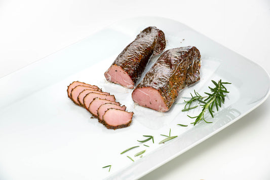 Hausgeräuchertes Schweinefilet im Alpenkräutermantel delikat präsentiert