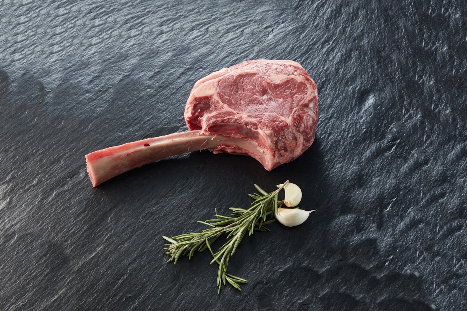 Frisches Tomahawk Steak aug Granitplatte